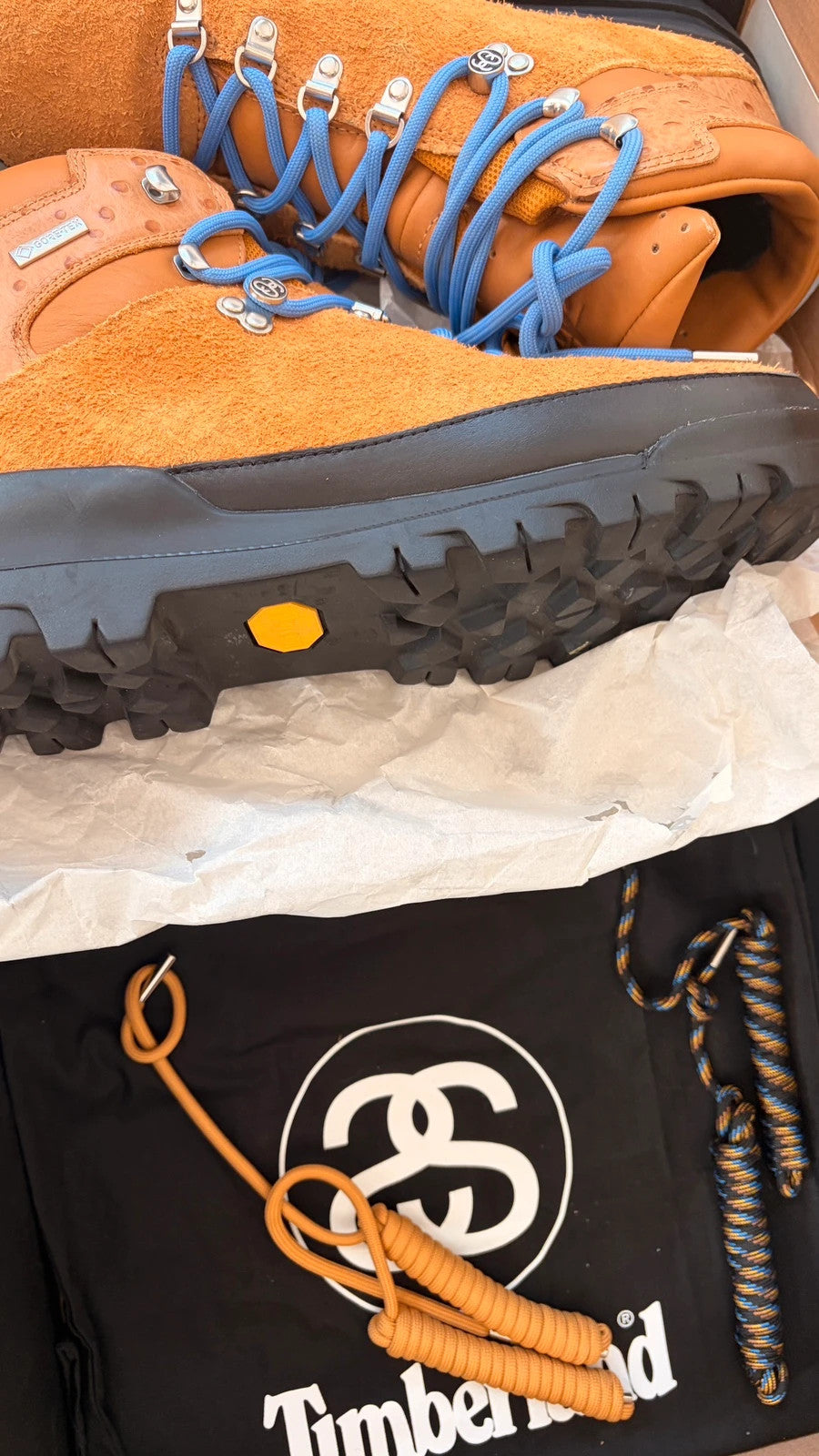 Stüssy x Timberland brown and orange hiking sandals with logo detailing and rugged sole.